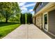 Concrete patio with stone and siding home exterior and mature evergreen trees at 725 Sugarbush Dr, Zionsville, IN 46077