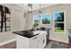 Modern kitchen with white cabinets, a farmhouse sink, and black countertops at 1647 Sheldon St, Indianapolis, IN 46218