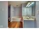 Well-lit bathroom features a double sink vanity, large mirror, and a soaking tub at 2225 Shadowbrook Dr, Plainfield, IN 46168