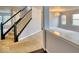 Carpeted staircase with black banister and views into the living room at 2225 Shadowbrook Dr, Plainfield, IN 46168
