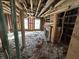 Living room showing exposed framing, brick fireplace, and two windows, ready for renovation at 4026 W 141St St, Carmel, IN 46074