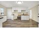Bright, updated kitchen with sleek white cabinets, modern fixtures, and wood-look flooring; ready for culinary adventures at 7635 Grizzly Dr, Nineveh, IN 46164