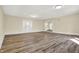 Spacious living room featuring wood-look flooring, fresh neutral paint, and ample natural light from the front door at 7635 Grizzly Dr, Nineveh, IN 46164