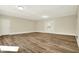 Spacious living room featuring wood-look flooring, fresh neutral paint, and ample natural light from the door at 7635 Grizzly Dr, Nineveh, IN 46164