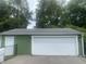 Spacious two-car garage with green siding and white door, offering ample parking at 6438 Doris Dr, Indianapolis, IN 46214