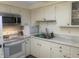 Bright kitchen with white cabinetry, stainless steel appliances, and a brick backsplash at 6438 Doris Dr, Indianapolis, IN 46214