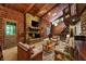 Spacious living room featuring a stone fireplace, log walls, and comfortable seating, perfect for cozy gatherings at 9307 E Dill Rd, Morgantown, IN 46160