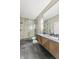 Modern bathroom featuring a double sink vanity, walk-in shower with stone-look walls, and gray tiled floor at 9700 Windy Hills Dr, Zionsville, IN 46077