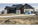 Stunning new construction home featuring a modern design with stone accents and a three-car garage at 9700 Windy Hills Dr, Zionsville, IN 46077