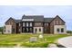Beautiful modern home with a well-manicured front lawn and attractive mixed material facade at 9700 Windy Hills Dr, Zionsville, IN 46077