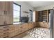 Bright kitchen featuring modern wood cabinets, black countertops and trim, and a designer rug at 9700 Windy Hills Dr, Zionsville, IN 46077