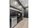Kitchenette featuring sleek black cabinets, stainless steel appliances, light wood floors, and modern lighting at 9700 Windy Hills Dr, Zionsville, IN 46077