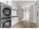 Convenient laundry area with a modern stacked washer and dryer unit, ample storage cabinets, and sleek countertops at 9700 Windy Hills Dr, Zionsville, IN 46077