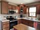Modern kitchen with stainless steel appliances and wood cabinets at 1144 Woodridge, Brownsburg, IN 46112