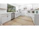 Contemporary kitchen boasts white cabinetry, stainless steel appliances, and wood-look flooring at 3031 N New Jersey St, Indianapolis, IN 46205