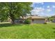 View of the house from the backyard, featuring a patio and large tree providing ample shade at 105 Tulip Dr, Indianapolis, IN 46227
