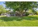 Backyard view of house with large tree shading a patio area, perfect for outdoor relaxation at 105 Tulip Dr, Indianapolis, IN 46227