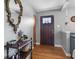 Warm entryway showcasing hardwood floors, dark wood door, decorative mirror, and stylish decor at 105 Tulip Dr, Indianapolis, IN 46227