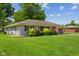 Picture of home's exterior featuring lush lawn, colorful shrubs, and a one-car attached garage on a sunny day at 105 Tulip Dr, Indianapolis, IN 46227