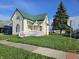 Charming two-story home featuring a green roof, front porch, and well-maintained lawn at 902 W Main St, Greenfield, IN 46140