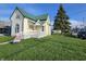 Charming two-story home with a green roof, front porch, and mature tree at 902 W Main St, Greenfield, IN 46140