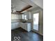 White kitchen cabinets, gray flooring and patio door access at 902 W Main St, Greenfield, IN 46140
