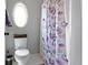 Charming bathroom featuring a toilet, an oval window, and a shower with a floral curtain for added privacy at 11633 Trail Ridge Pl, Zionsville, IN 46077