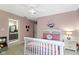 Cozy pink bedroom with a white bed frame, decorative floral wreath, and access to an ensuite bathroom at 11633 Trail Ridge Pl, Zionsville, IN 46077