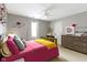 Bright bedroom featuring a colorful decor, window, dresser, and plush pillows, illuminated by a ceiling fan with light at 11633 Trail Ridge Pl, Zionsville, IN 46077
