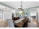 Open dining room with hardwood floors, a pendant light fixture, and soft green walls at 11633 Trail Ridge Pl, Zionsville, IN 46077