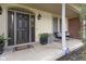 Charming front porch with black door, stylish seating, potted plants, and brick accents at 11633 Trail Ridge Pl, Zionsville, IN 46077