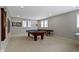 Spacious game room with a pool table, ping pong table, and ample natural light, perfect for entertaining guests at 11633 Trail Ridge Pl, Zionsville, IN 46077