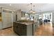 Full kitchen view showing a granite island, stovetop, and dining area next to a fireplace at 11633 Trail Ridge Pl, Zionsville, IN 46077
