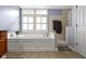 Bright bathroom featuring a soaking tub under the window and tiled floors at 11633 Trail Ridge Pl, Zionsville, IN 46077