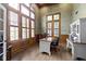 Elegant office with vaulted ceiling, large windows, shutters, hardwood floors, and wood trim at 11633 Trail Ridge Pl, Zionsville, IN 46077