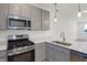 Modern kitchen with gray cabinets and stainless steel appliances at 3885 Wren Dr, Brownsburg, IN 46112