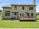 Backyard view showcasing the home's wooden deck, large yard, neutral siding and large sliding glass doors at 1936 Broadmoor Ln, Columbus, IN 47203