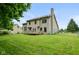 Large backyard featuring a well-maintained lawn, wooden deck, and mature trees, perfect for outdoor activities at 1936 Broadmoor Ln, Columbus, IN 47203