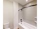 Clean bathroom with a bathtub and shower, gray tile, and modern fixtures at 9870 Bucklebury Ln, Carmel, IN 46280