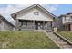 Charming two-story home featuring a covered porch and professionally landscaped front yard at 1210 Finley Ave, Indianapolis, IN 46203
