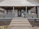 Inviting covered front porch with wood ceiling, brick columns and sitting area at 1210 Finley Ave, Indianapolis, IN 46203