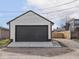 A standalone garage with a large, gray door and steps leading up to the entrance at 1210 Finley Ave, Indianapolis, IN 46203