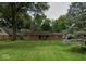 Charming ranch-style home featuring a brick facade and a well-maintained lawn, framed by mature trees at 9634 Maple Dr, Carmel, IN 46280