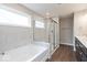 Bright bathroom featuring a shower with glass doors, a soaking tub, and a double vanity at 1099 Gatewick Ct, Greenwood, IN 46143