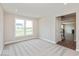 Bright bedroom with large window, carpeted floors and gray walls with hall access at 1099 Gatewick Ct, Greenwood, IN 46143