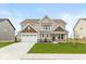 Beautiful two-story home with a manicured lawn, stone accents, covered porch, and attached two-car garage at 1099 Gatewick Ct, Greenwood, IN 46143