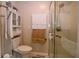 Bathroom featuring a walk-in shower, white toilet, and wall storage at 5964 Laramie Trl, Columbus, IN 47203
