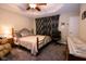 Bedroom featuring a tray ceiling with a ceiling fan and a wrought iron bed frame at 5964 Laramie Trl, Columbus, IN 47203