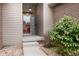 Close-up of front entrance featuring a glass door, brick accents, and green shrubs enhancing the curb appeal at 5964 Laramie Trl, Columbus, IN 47203