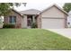 Charming single-story home featuring a well-maintained lawn, brick accents, and an attached two-car garage at 5964 Laramie Trl, Columbus, IN 47203
